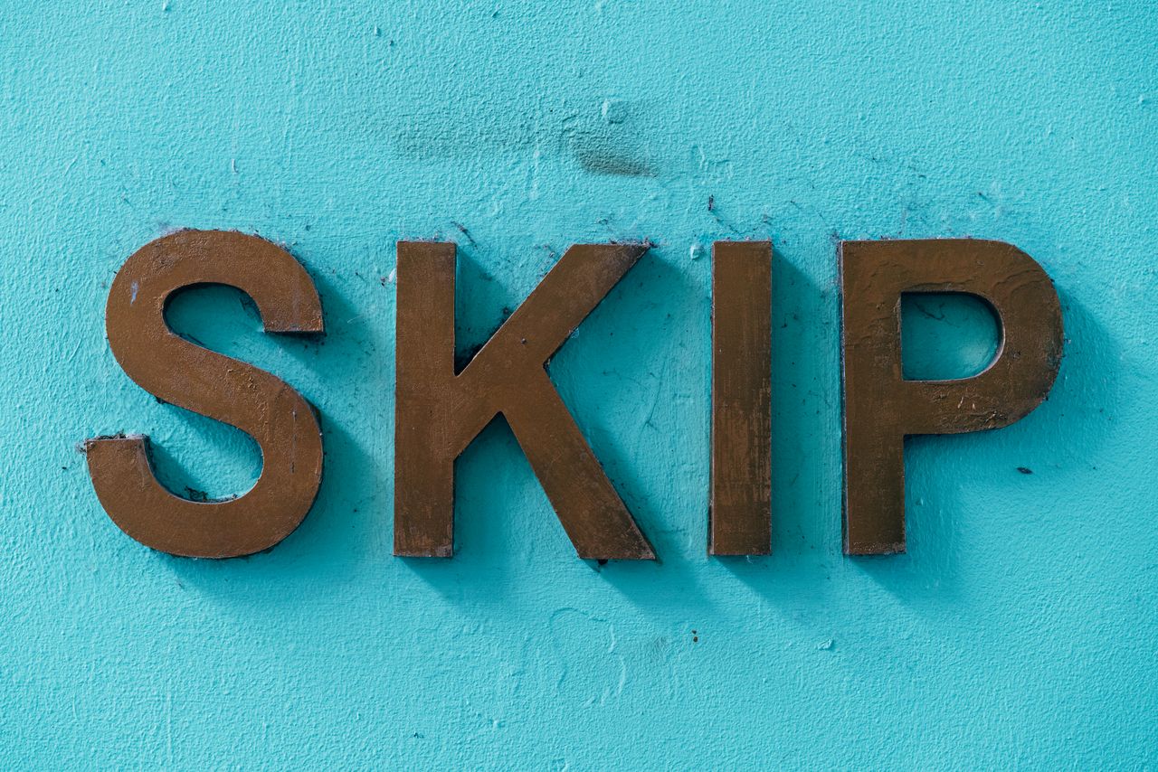 An artistic photograph of the word SKIP against a textured background