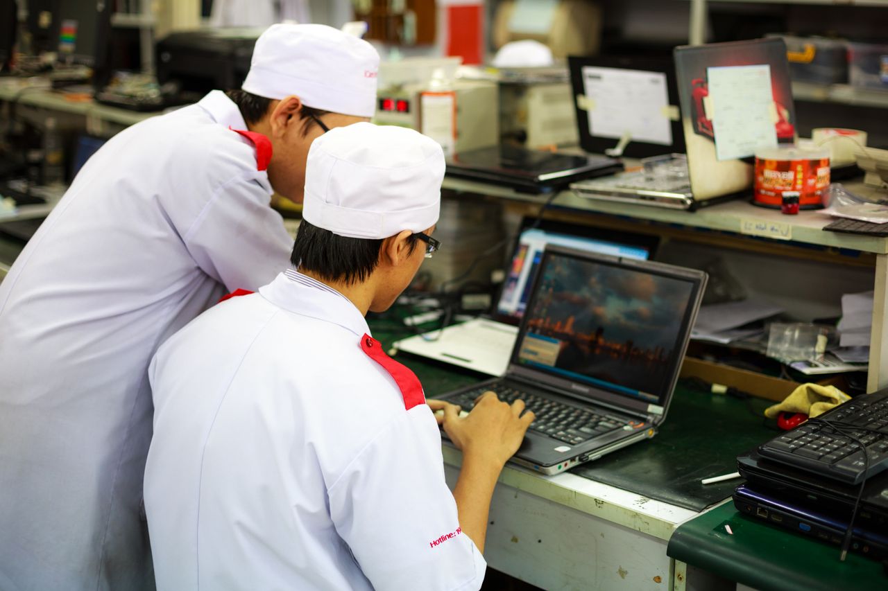 Photograph of two employees looking at a laptop