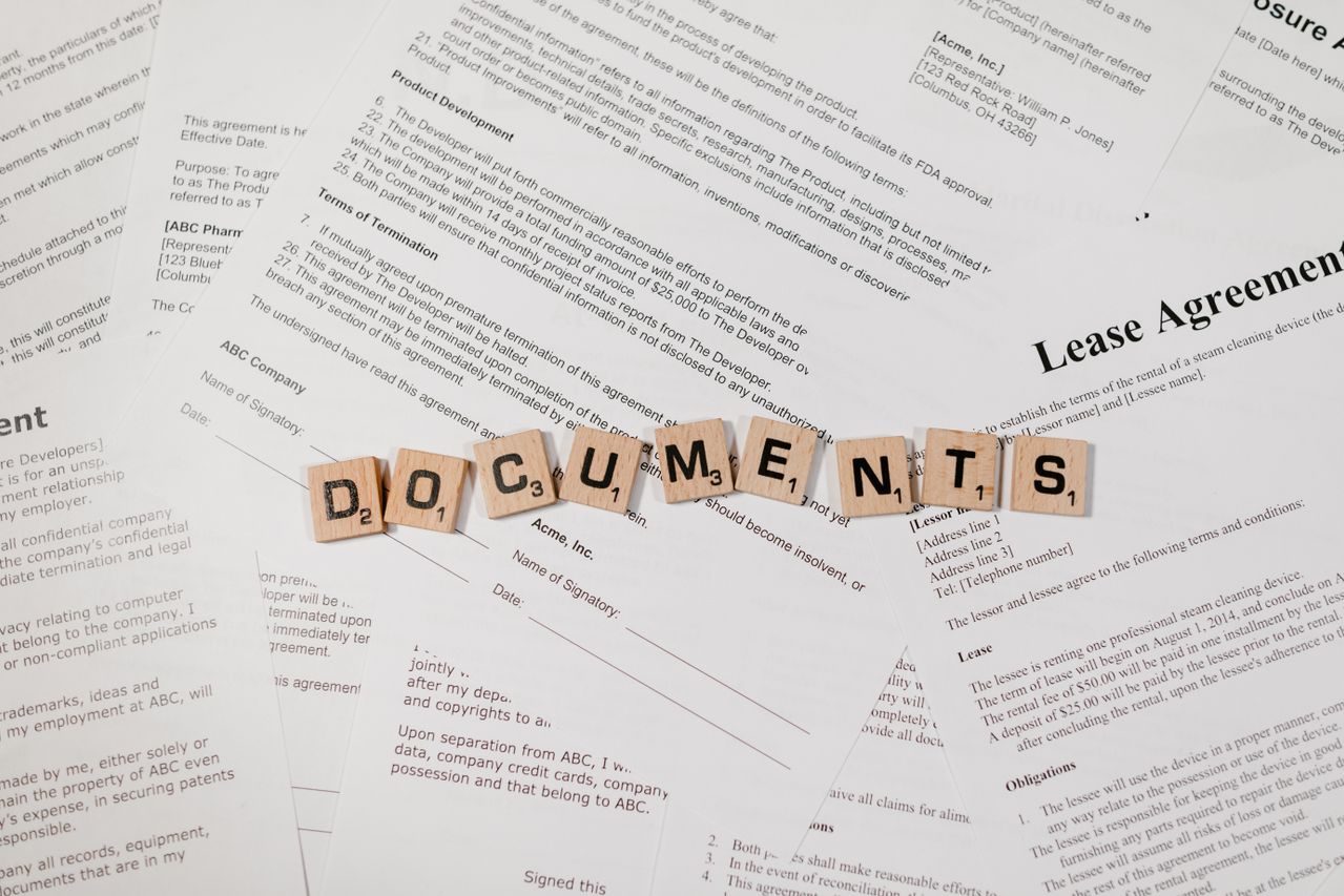 A photograph showing the word Document written in scrabble letters on top of various printed paper documents