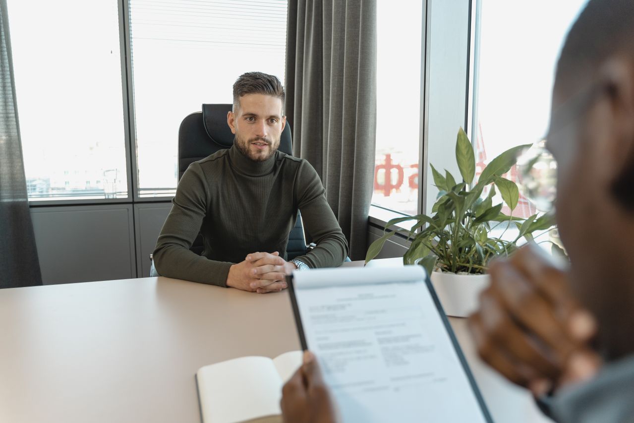Photograph of person sat at a desk in a job interview
